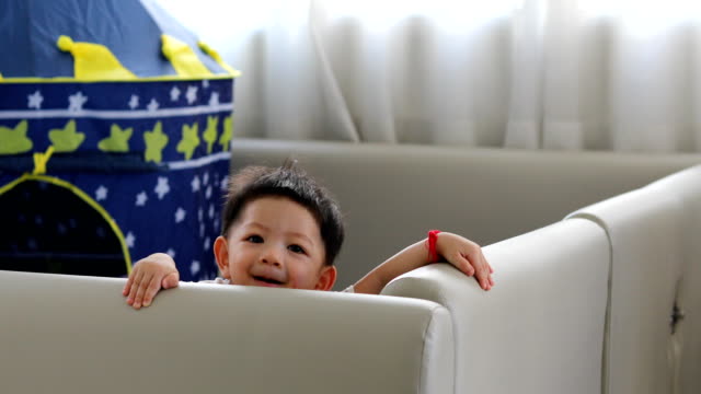 cute-baby-boy-happy-in-living-room-with-soft-pad-mattress-partition-limit-area-self-protection-in-family-home