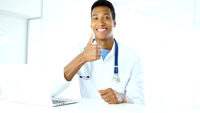 Thumbs-Up-by-Afro-American-Doctor-in-Clinic