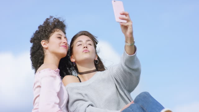 Schönen-multiethnischen-Freundinnen-draußen-posiert-für-selfie