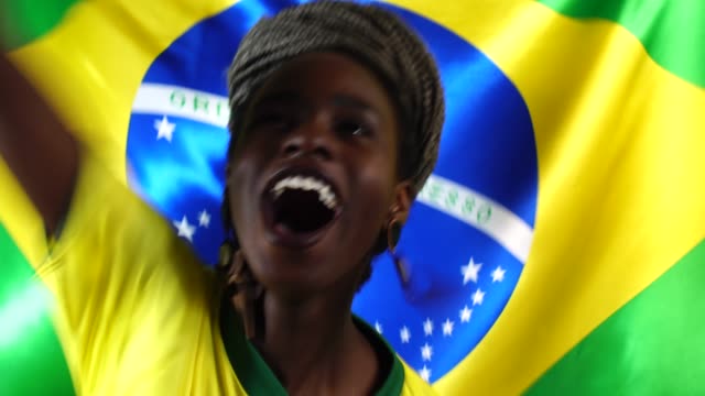 Brasilianische-junge-schwarze-Frau-feiert-mit-Brasilien-Flagge