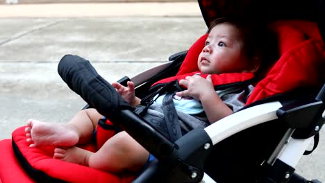 cute-boy-child-laughing-happy-smile-in-baby-stroller-carriage-seat