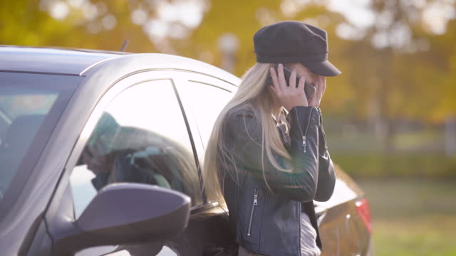 Schöne-junge-Blonde-telefonieren-mit-dem-Auto