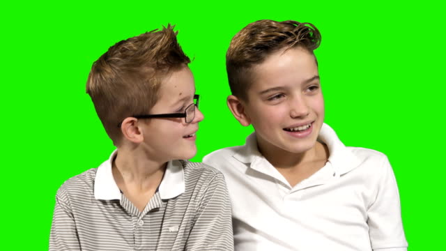 Zwei-Brüder,-die-lachend-auf-grünem-Hintergrund