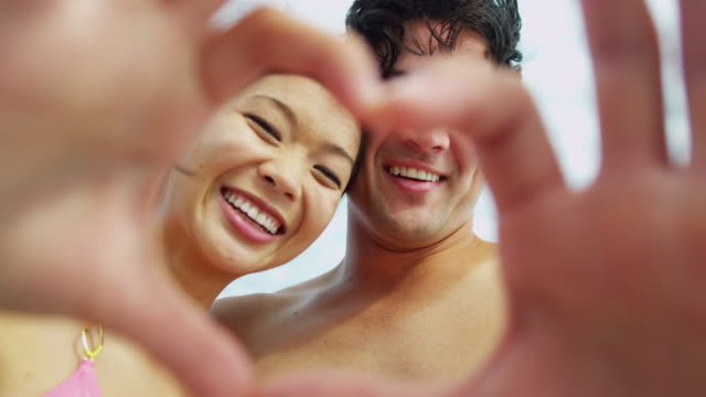 Ethnic-couple-heart-shape-hands-messaging-family-friends