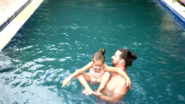 Familia-feliz,-activo-padre-con-niño-pequeño,-hija-de-niño-adorable,-divirtiéndose-en-la-piscina.