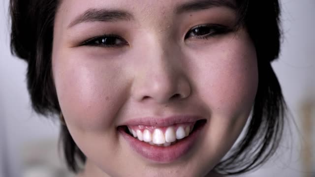 Porträt-des-jungen-glücklich-Brünette-Asiatin,-Blick-in-die-Kamera,-lächelndes-Gesicht.-50-fps