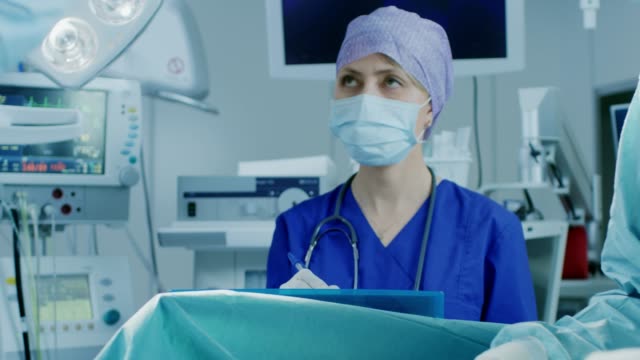 En-la-sala-de-operaciones-Hospital-de-equipo-diverso-de-profesionales-cirujanos-y-enfermeras-la-sutura-herida-después-de-la-cirugía-exitosa.