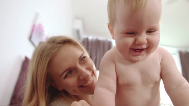 Naked-baby-with-five-teeth-smile.-Happy-baby-with-mother-smiling-and-have-fun