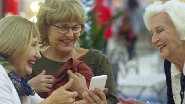 Ältere-Frauen-lachen-über-Smartphone-Fotos