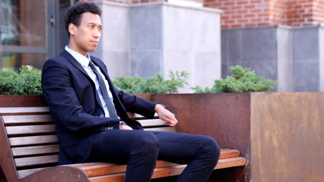 Pensive-Serious-African-Businessman-Sitting-on-Bench