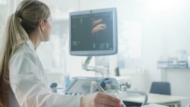 En-el-Hospital,-el-obstetra-utiliza-transductor-para-ultrasonido-/-ecografía-de-detección-/-escaneo-del-vientre-de-la-mujer-embarazada.-Pantalla-de-la-computadora-muestra-la-imagen-3D-del-bebé-de-forma-saludable.