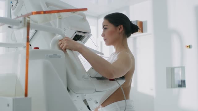In-the-Hospital,-Portrait-Shot-of-Topless-Female-Patient-Undergoing-Mammogram-Screening-Procedure.-Healthy-Young-Female-Does-Cancer-Preventive-Mammography-Scan.-Modern-Hospital-with-High-Tech-Machines.