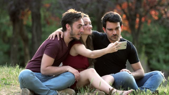 Tres-jóvenes-amigos-hacen-Selfie-en-el-Parque-selfie,-alegría,-sin-preocupaciones