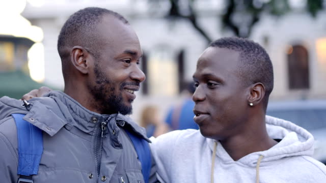 Zwei-junge-schwarze-afrikanische-Freunde-sprechen-und-Lächeln-auf-der-Straße
