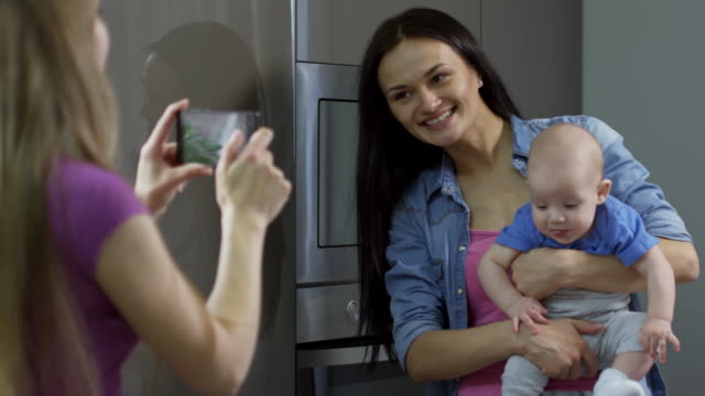 Mother-Taking-Picture-of-Female-Partner-with-Baby