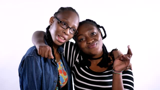 Zwei-junge-afrikanische-amerikanische-Frauen-umarmten-und-lächelt-in-die-Kamera,-glücklich,-isoliert-auf-weißem-Hintergrund-schwarze-Freunden-lachen