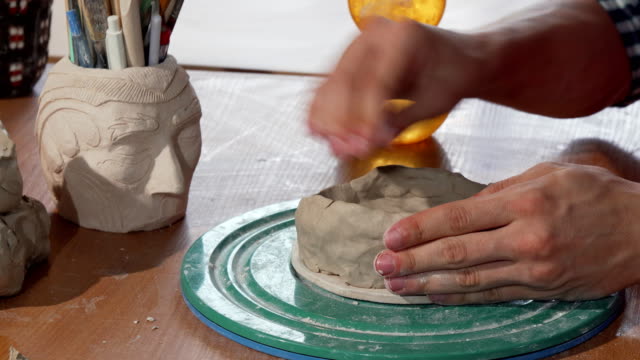 Ceramics-artist-shaping-clay,-creating-a-bowl-at-his-workshop
