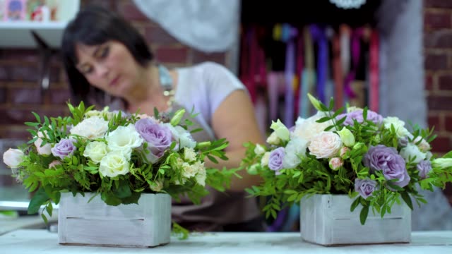 professionellen-Floristen-arrangieren-schöne-Blume-Zusammensetzung-in-Holzkiste-im-floralen-Designstudio