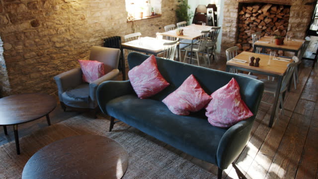Leere-Lounge,-Essbereich-und-Bar-in-einem-Gastro-Pub-bei-Tageslicht-mit-Funktion-Steinmauern-und-alten-Holzdielen,-handheld,-erhöht,-Ansicht