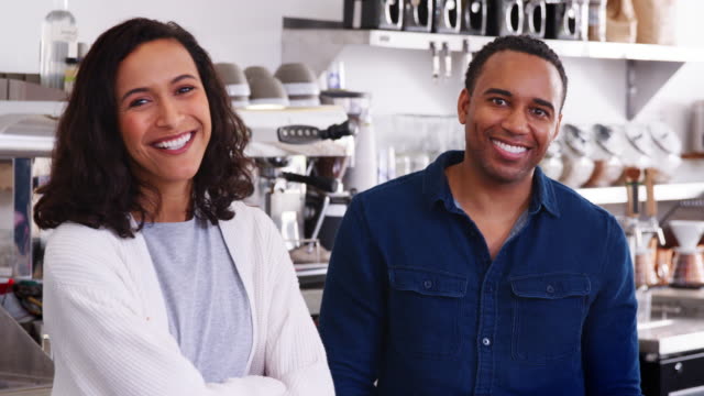 Mixed-race-couple-behind-the-counter-at-their-coffee-shop
