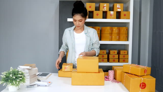 young-woman-entrepreneur-arranging-a-box-to-be-delivered-to-customers