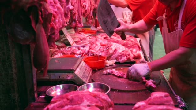 Carnicero-cortando-carne-cruda-en-un-mercado-de-carne-en-Hong-Kong