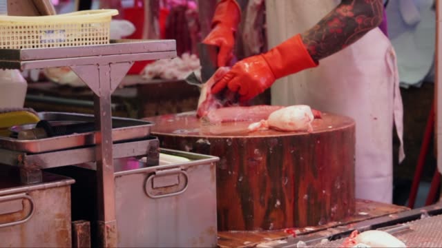 Metzger-bei-der-Arbeit,-schneiden-und-verpacken-Fisch-auf-einem-Hackstock-am-Fleischmarkt