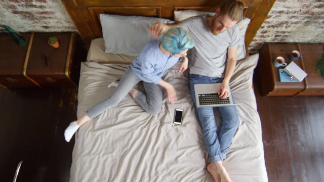 Woman-Joining-Boyfriend-Working-from-Bed