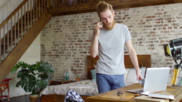 Hipster-Man-Talking-on-Phone-in-Loft-Apartment