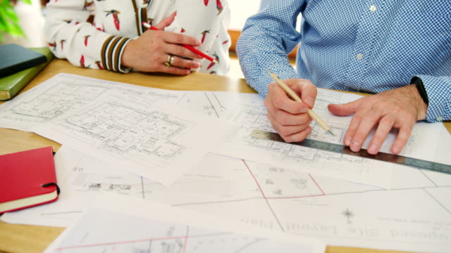 Dibujar-y-discutir-planes-de-la-casa-en-su-estudio-de-arquitectos