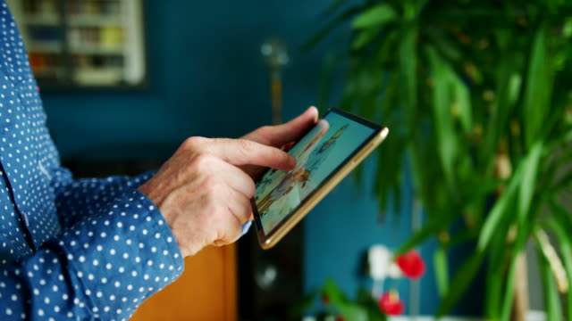 Businessman-Swiping-Through-Digital-Tablet-At-Home-Office