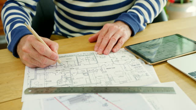 Architekten-arbeiten-am-Design-Baupläne-an-seinem-Schreibtisch
