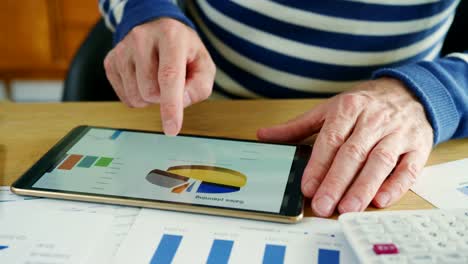 Businessman-Analysing-Financial-Data-Using-A-Digital-Tablet