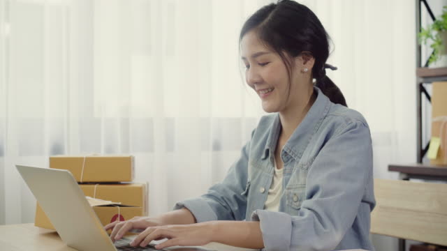 Schöne-intelligente-asiatischen-jungen-Unternehmer-Frau-Eigentümer-von-KMU-Online-Check-Produkt-auf-Lager-und-speichern-auf-Computer-zu-Hause-arbeiten.-Kleinunternehmer-im-home-Office-Konzept.