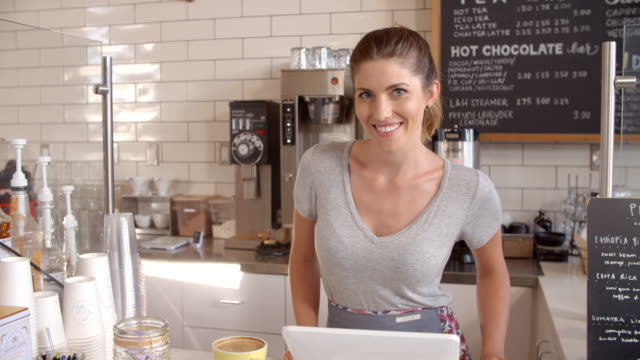 Woman-behind-the-counter-of-a-coffee-shop-crosses-arms