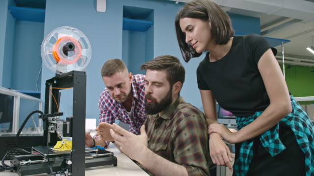 Männliche-Ingenieure-mit-Bart-3D-Druck-Kollegen-erklären