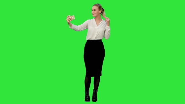 Junge-hübsche-Geschäftsfrau-nehmen-Selfie-mit-Handy-auf-einem-Green-Screen,-Chroma-Key