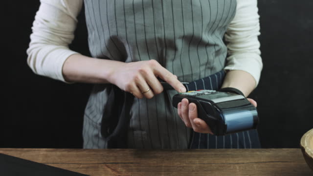 Woman-swiping-credit-card-through-credit-card-reader