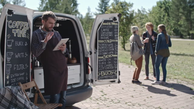 Besitzer-von-mobilen-Kaffee-Van-Blick-auf-Tablet