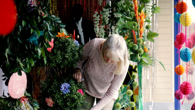 Senior-Business-Owner-Mending-her-Plants