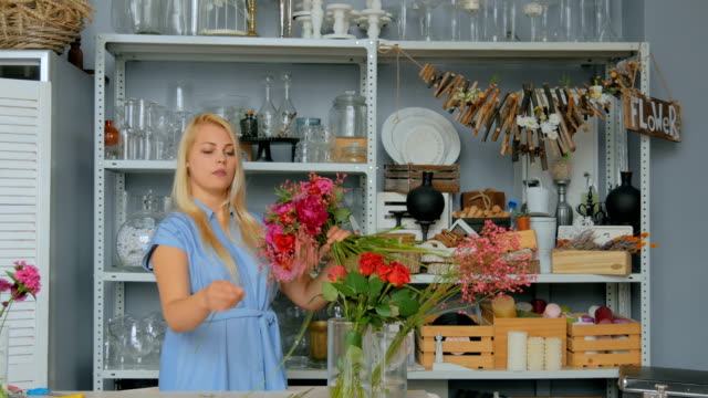 Professional-florist-making-beautiful-bouquet-at-flower-store
