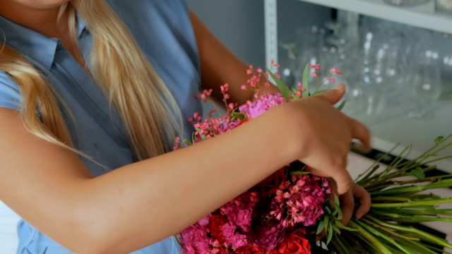 Professional-florist-holding-and-checking-bouquet-at-studio