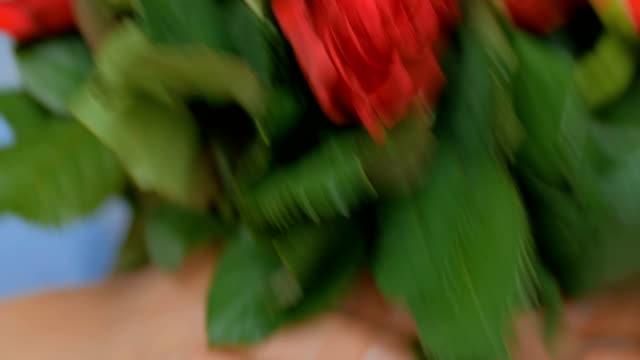 Professionellen-Floristen-Vorbereitung-rote-Rosen-Strauß-am-workshop
