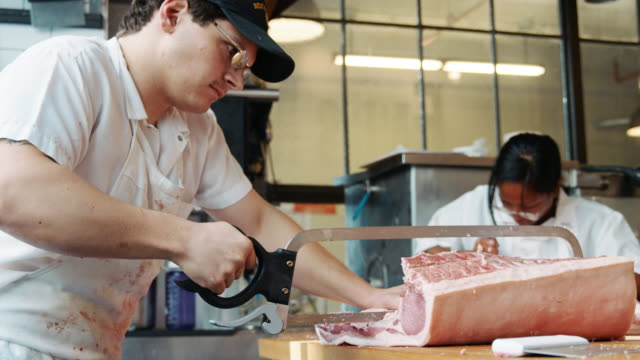 Dos-carniceros-preparando-carne-a-la-venta-en-una-carnicería