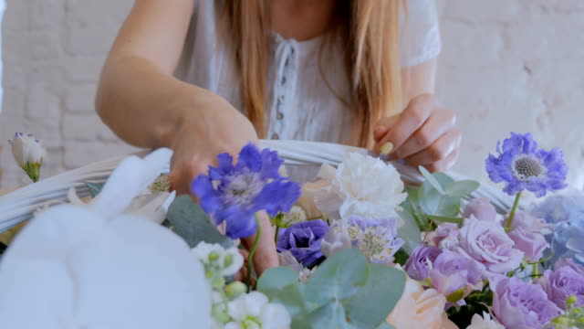 Florist-making-large-floral-basket-with-flowers-at-flower-shop