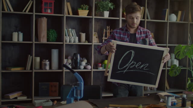 Small-business-owner-holding-an-open-sign.-Entrepreneur-starting-business
