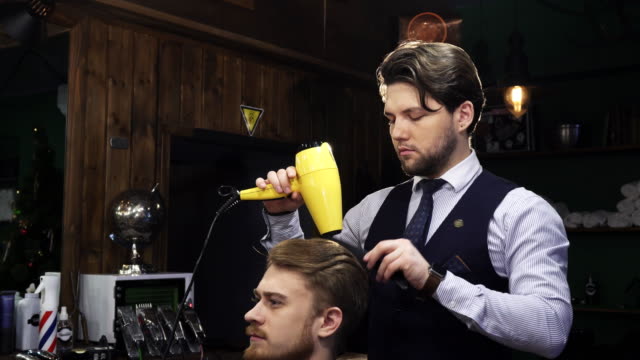 Handsome-bearded-professional-barber-working-with-his-client