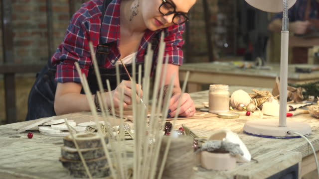 Young-Hipster-Painting-Handmade-Goods-in-her-Studio