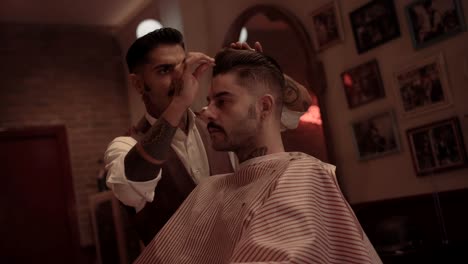 Hipster-hairdresser-styling-customer's-hair-at-old-fashioned-barber-shop