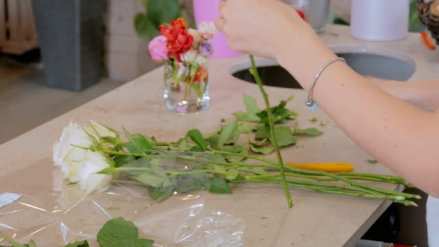 Professioneller-floral-Künstler-arbeiten-mit-Blumen-im-studio